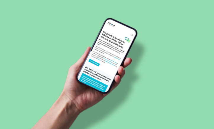 Main tenant un smartphone avec un site web ouvert, le tout sur fond vert